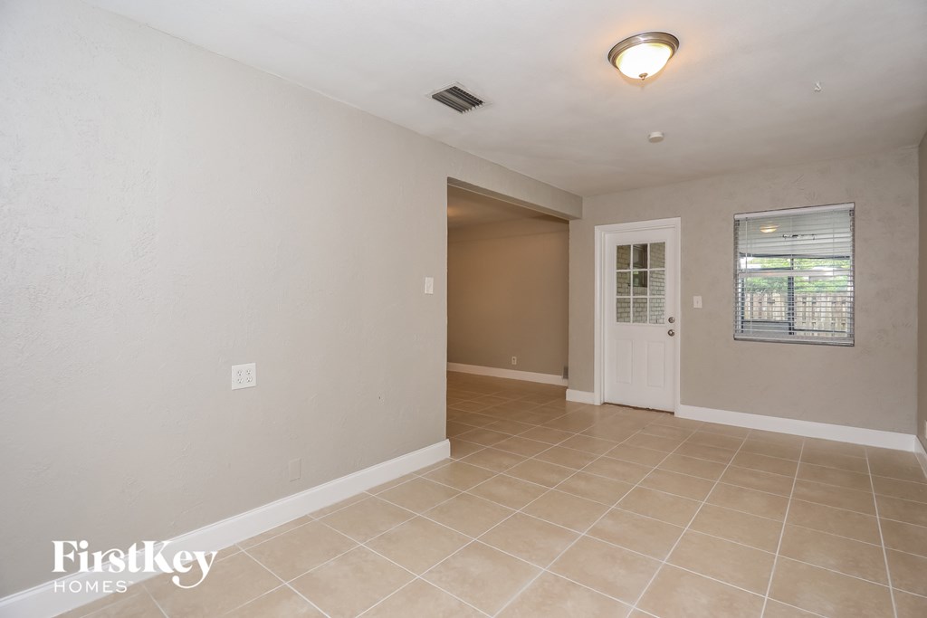A room with a white door and a window with blinds.