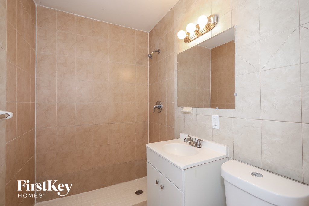 A bathroom with a white sink and a white toilet.