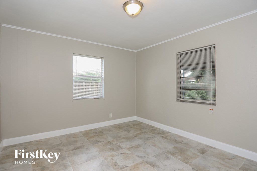 A room with a tiled floor and a window with blinds.