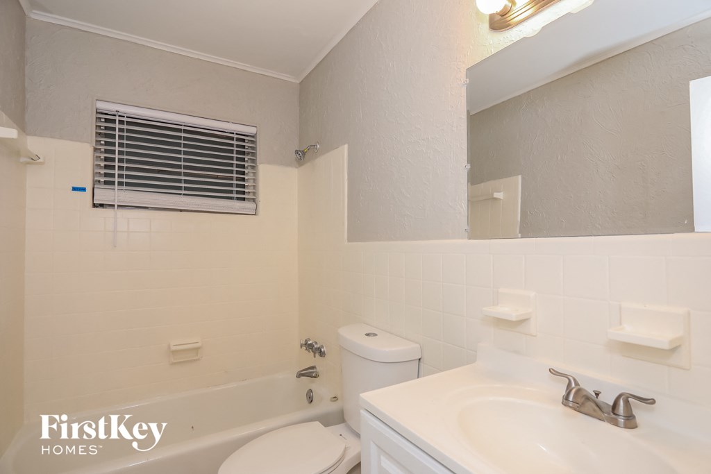A white bathroom with a toilet, sink, and tub.