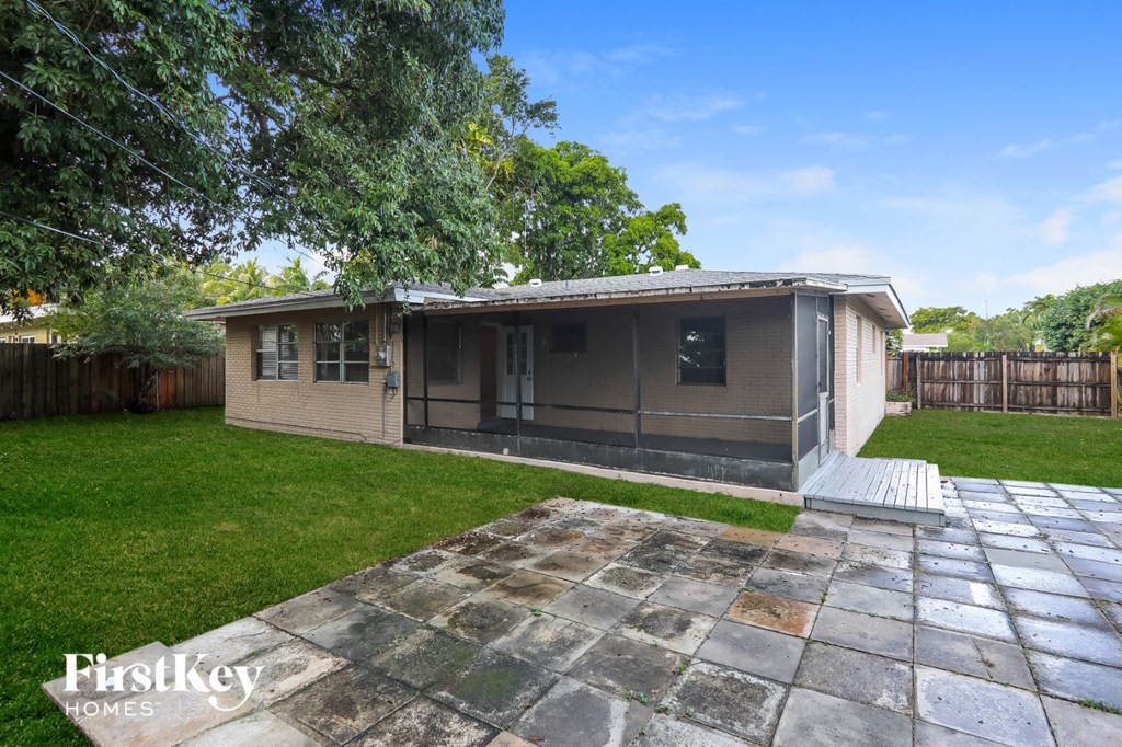 A house with a stone patio in front of it.