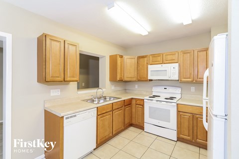 A kitchen with wooden cabinets and white appliances.