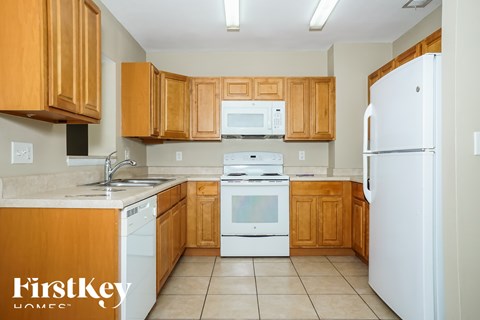 A kitchen with wooden cabinets and white appliances.