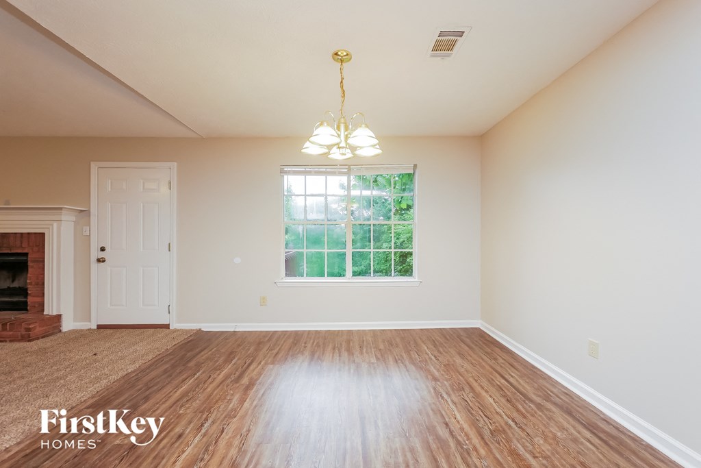 an empty living room with a fireplace and a window