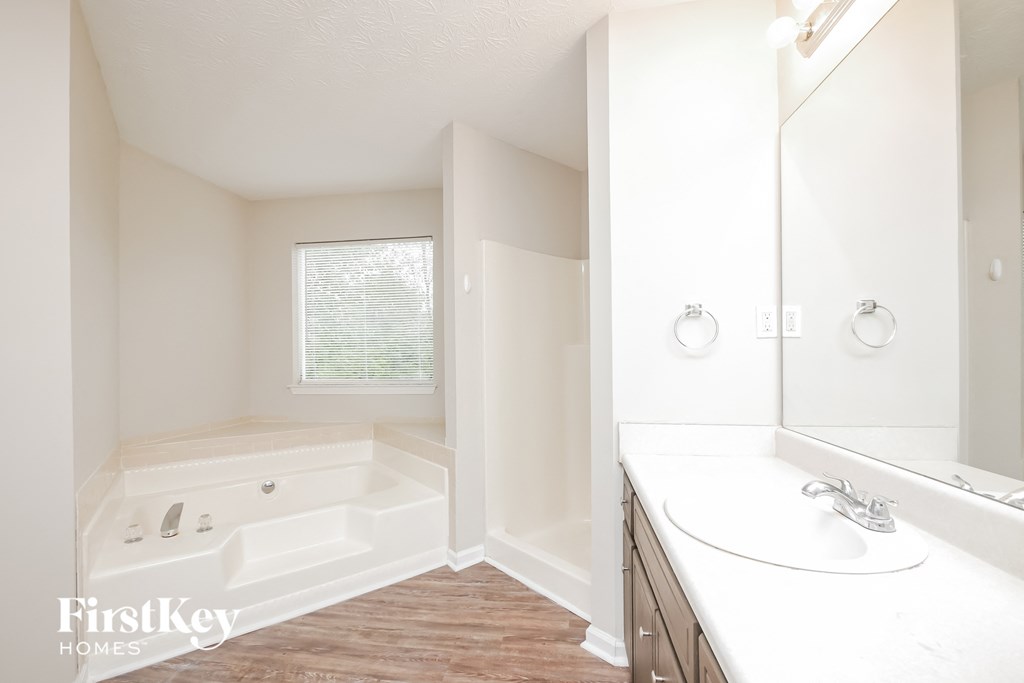 a bathroom with a tub and a sink and a mirror