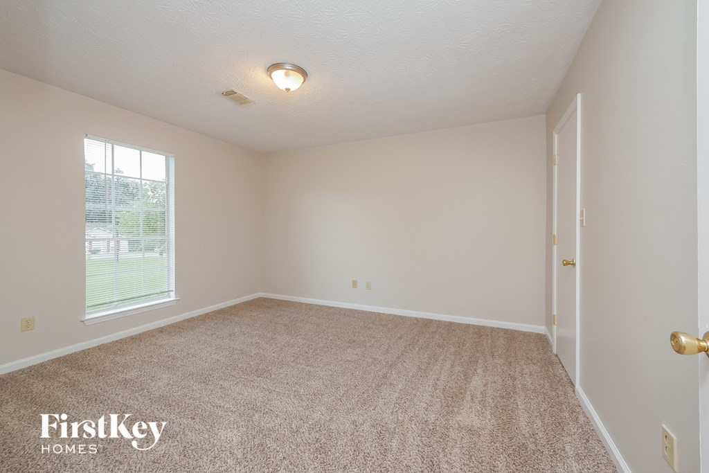 a spacious living room with carpet and a large window