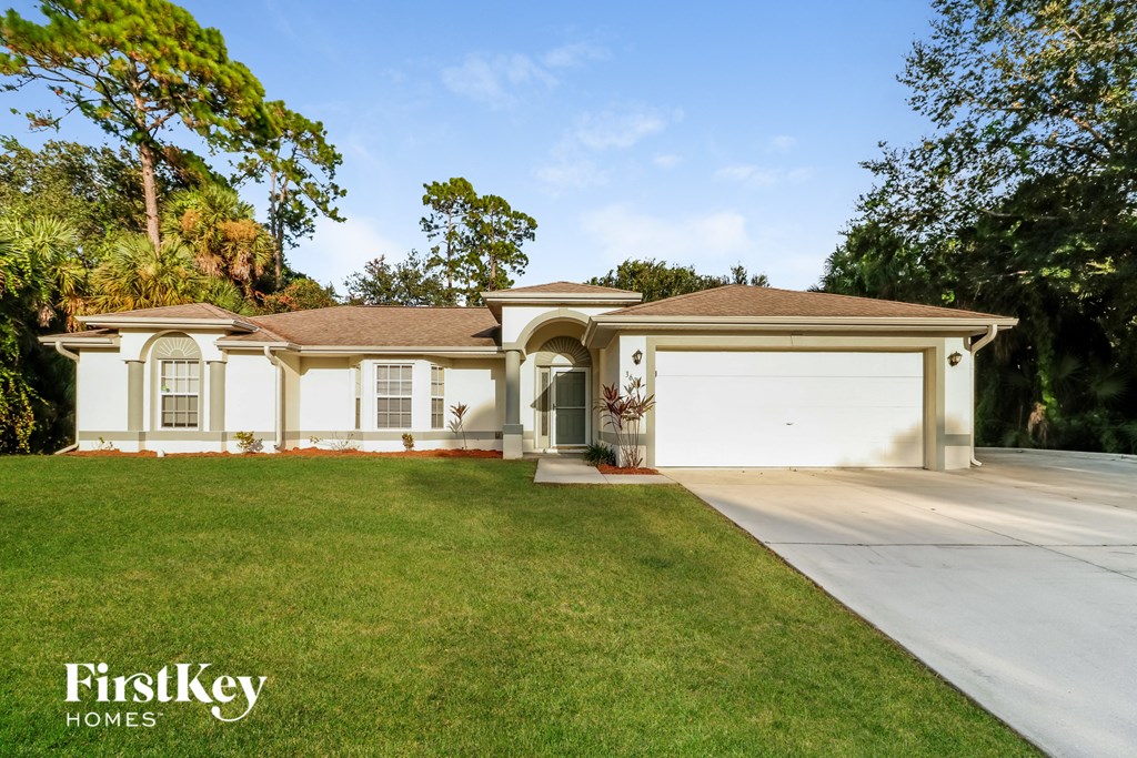 a white house with a driveway and a garage door