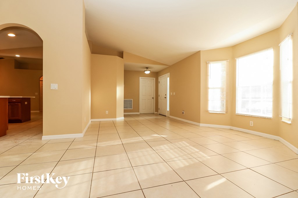 an empty living room with tiled floors and windows