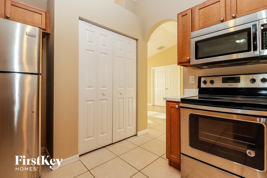 a kitchen with stainless steel appliances and a door to the hallway