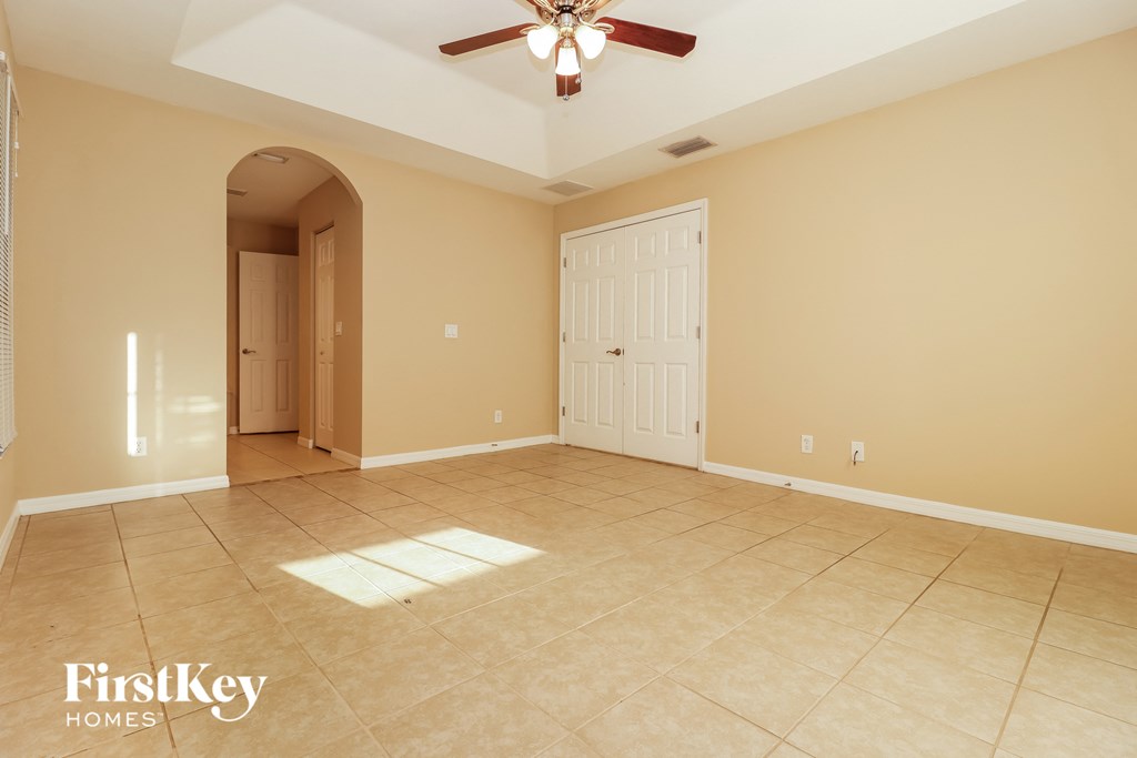 a empty living room with a ceiling fan