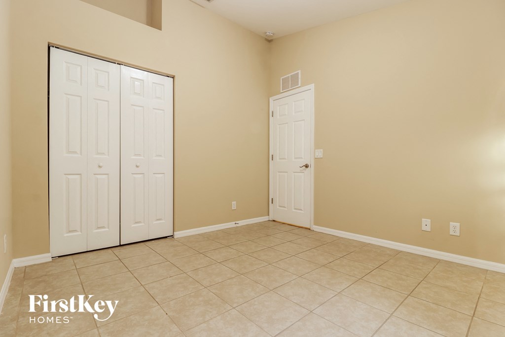 a room with two closets and a tiled floor and two doors