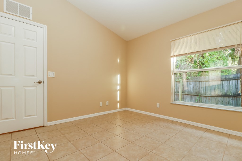 a living room with a large window and a tiled floor