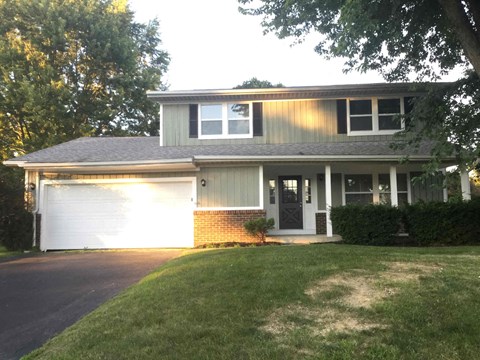 a house with a white garage door and a lawn