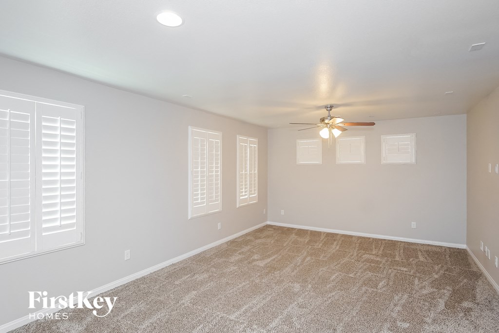 the living room of an empty house with a ceiling fan