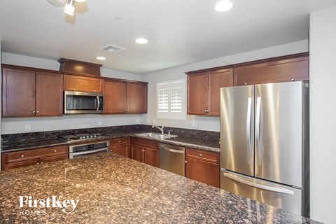 an updated kitchen with granite counter tops and stainless steel appliances
