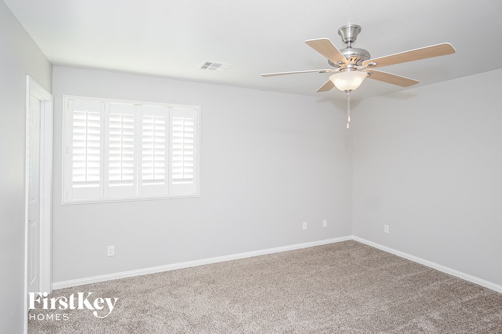 a empty room with a ceiling fan and a window