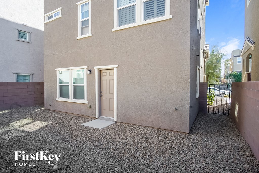 the front door of a house with a driveway and a gate
