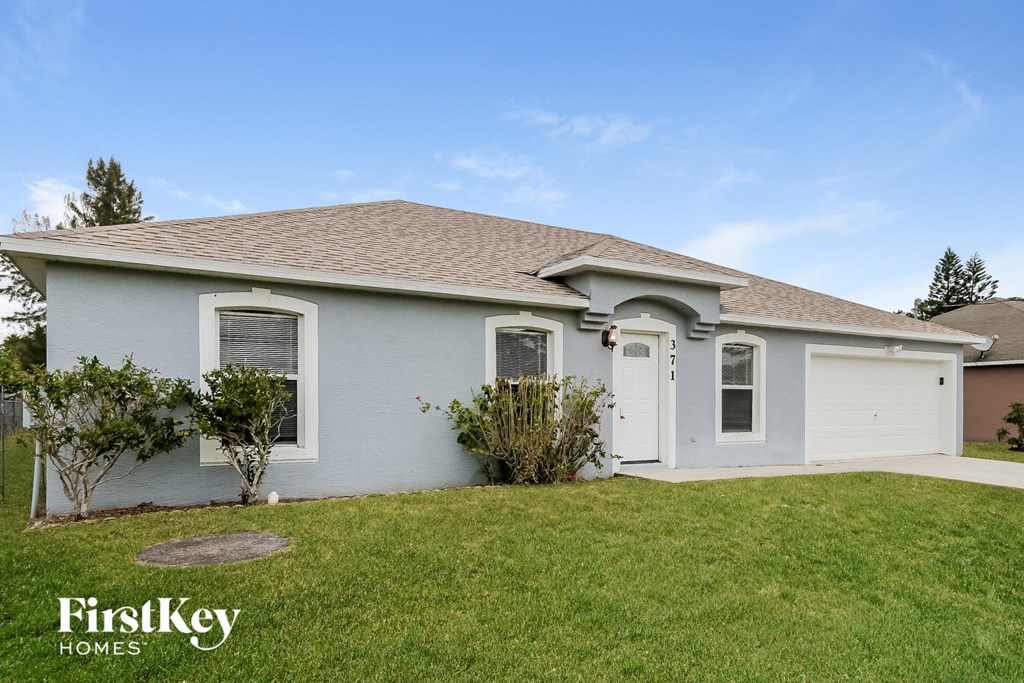 A house with a garage and a driveway is for sale.