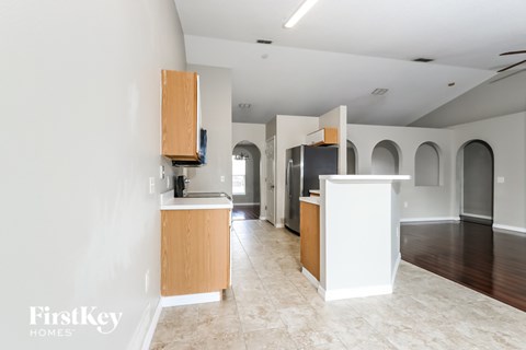 A kitchen area with a white counter and wooden cabinets.