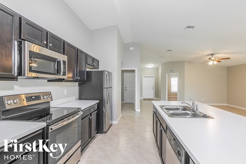 A kitchen with black cabinets and stainless steel appliances.