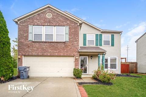 a home with a white garage door and a brick house