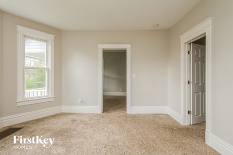 A room with a carpeted floor and a doorway leading to another room.