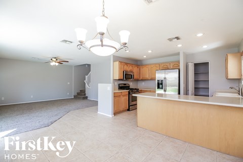 a large kitchen and dining room with a large island and a chandelier