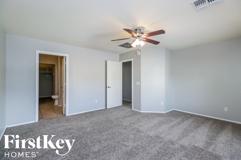 a living room with carpet and a ceiling fan