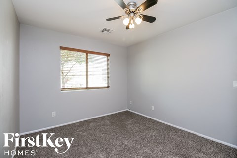 an empty room with a ceiling fan and a window