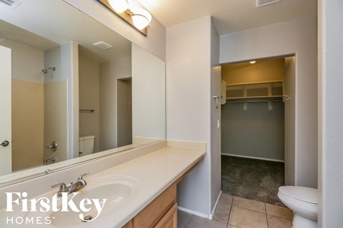 a bathroom with a large mirror and a sink and a toilet