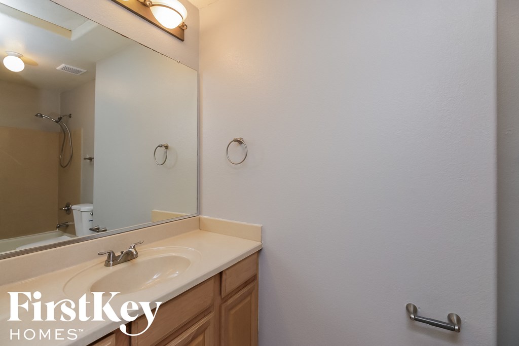 the bathroom has a large mirror and a sink