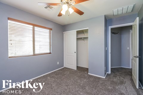 a bedroom with blue walls and a ceiling fan and a closet