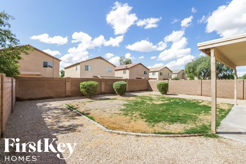 a backyard with a grassy area and a fence