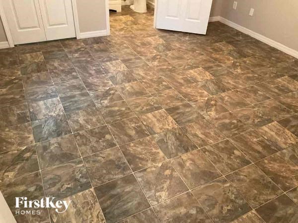 a bathroom with a tile floor and a white door