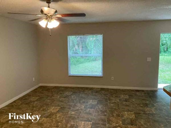 a empty room with a ceiling fan and a window