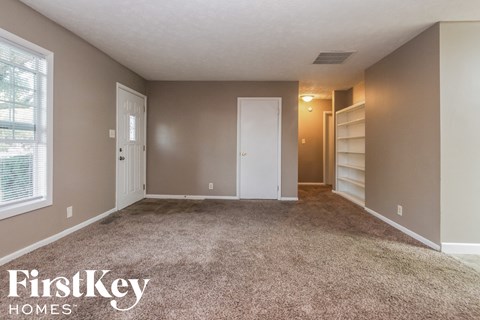 a bedroom with carpet and a closet and a window