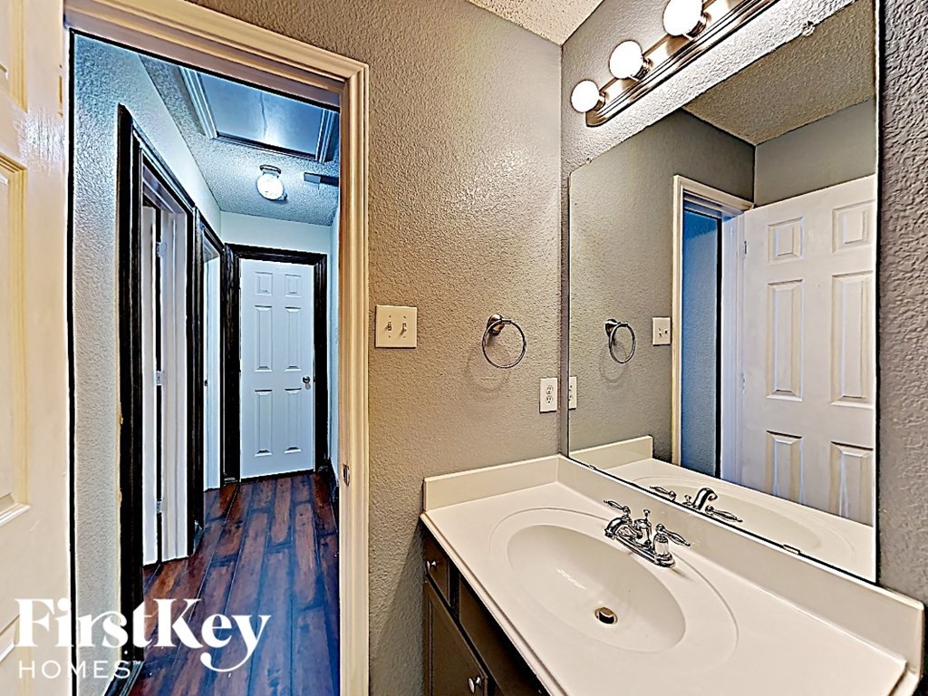 a bathroom with a sink and a mirror and a door