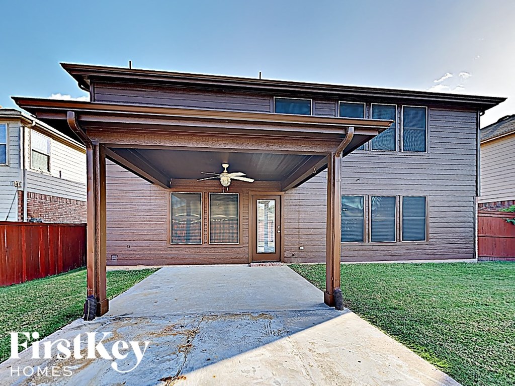 a home with a covered porch with a ceiling fan