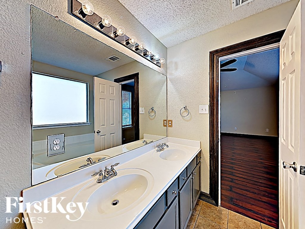 a bathroom with two sinks and a large mirror