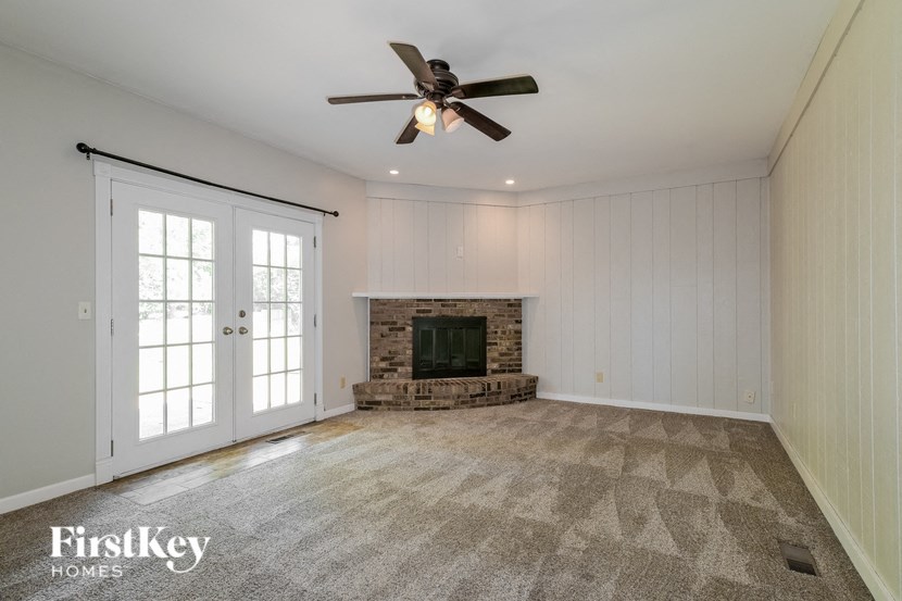 a living room with a fireplace and a ceiling fan