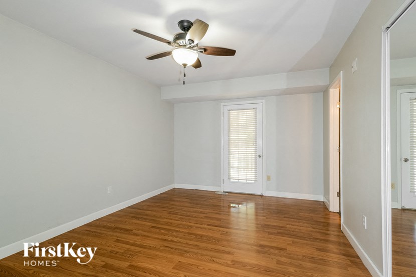 a living room with wood floors and a ceiling fan