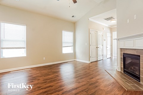 A spacious living room with wood floors and a fireplace.