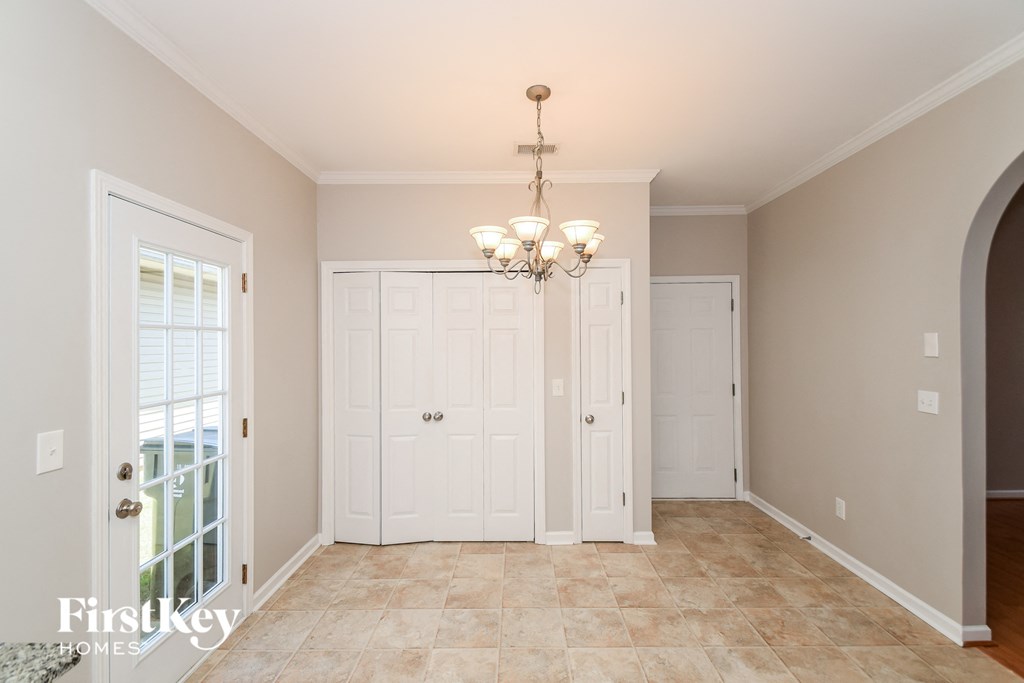 a dining room with a door and a chandelier