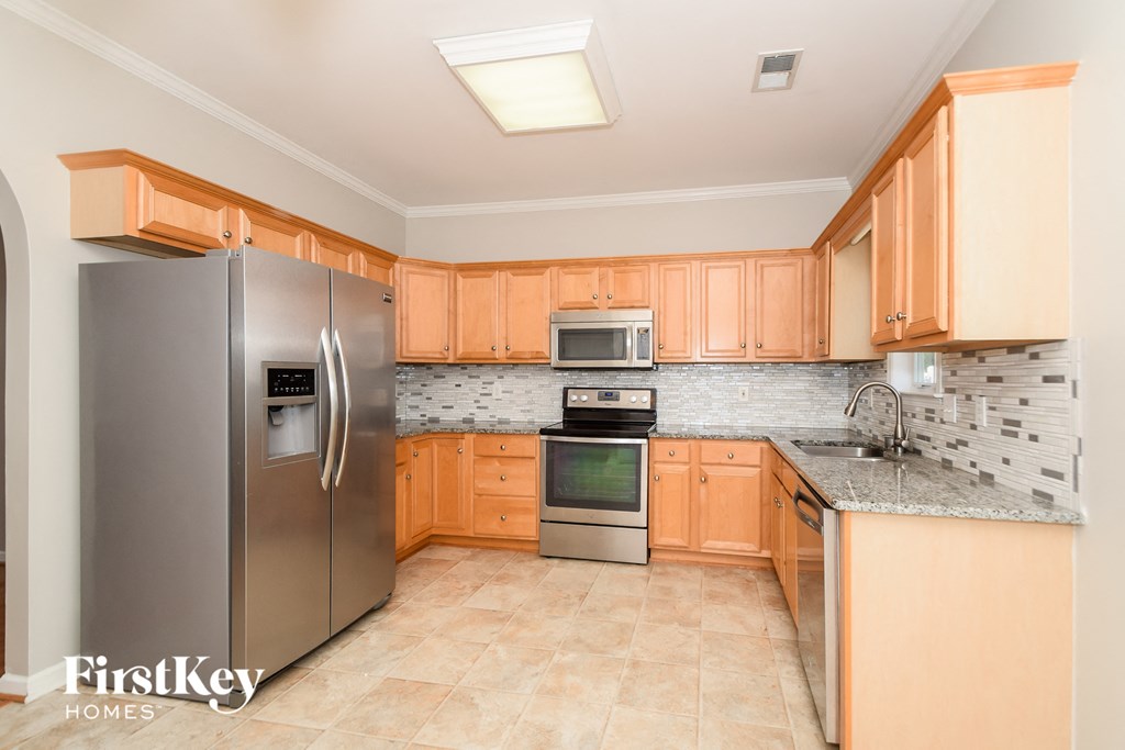 a kitchen with wooden cabinets and stainless steel appliances