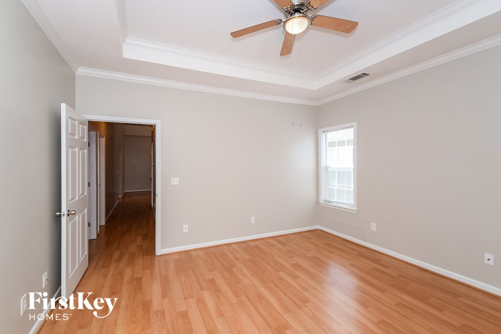 a living room with wood floors and a ceiling fan