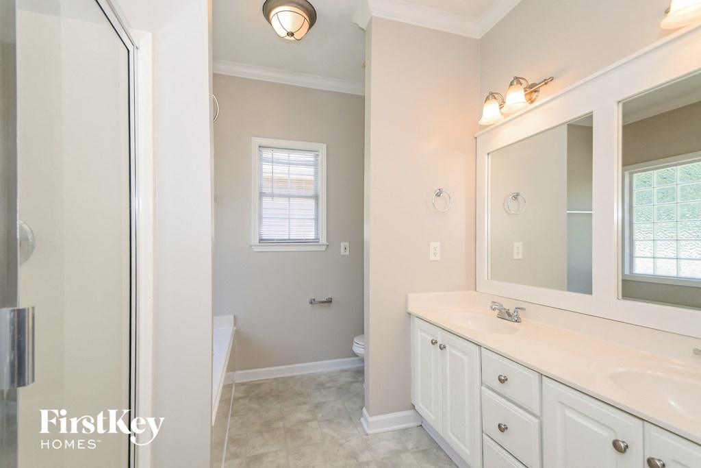a bathroom with a large mirror and a sink and a toilet