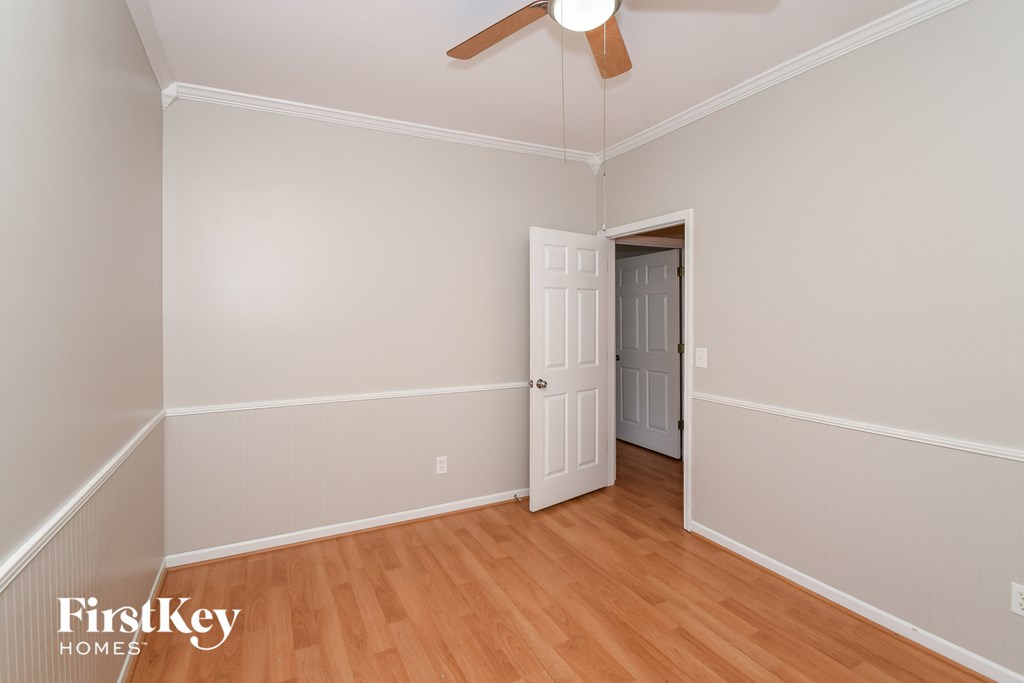 a bedroom with wood flooring and a door to a closet