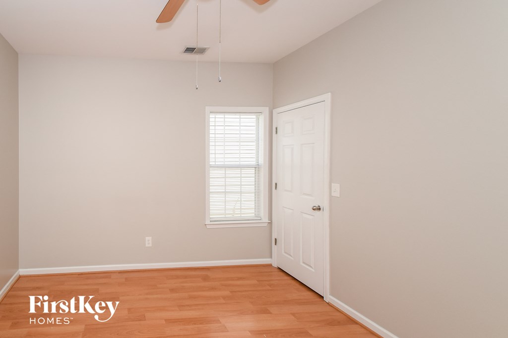 a bedroom with a door and a window and a wood floor