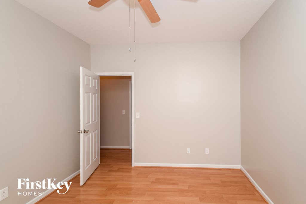 a bedroom with wood flooring and a door to a closet