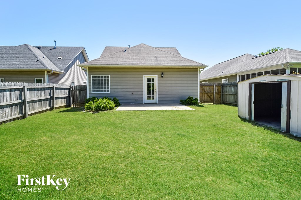 a backyard with a white house and a garage